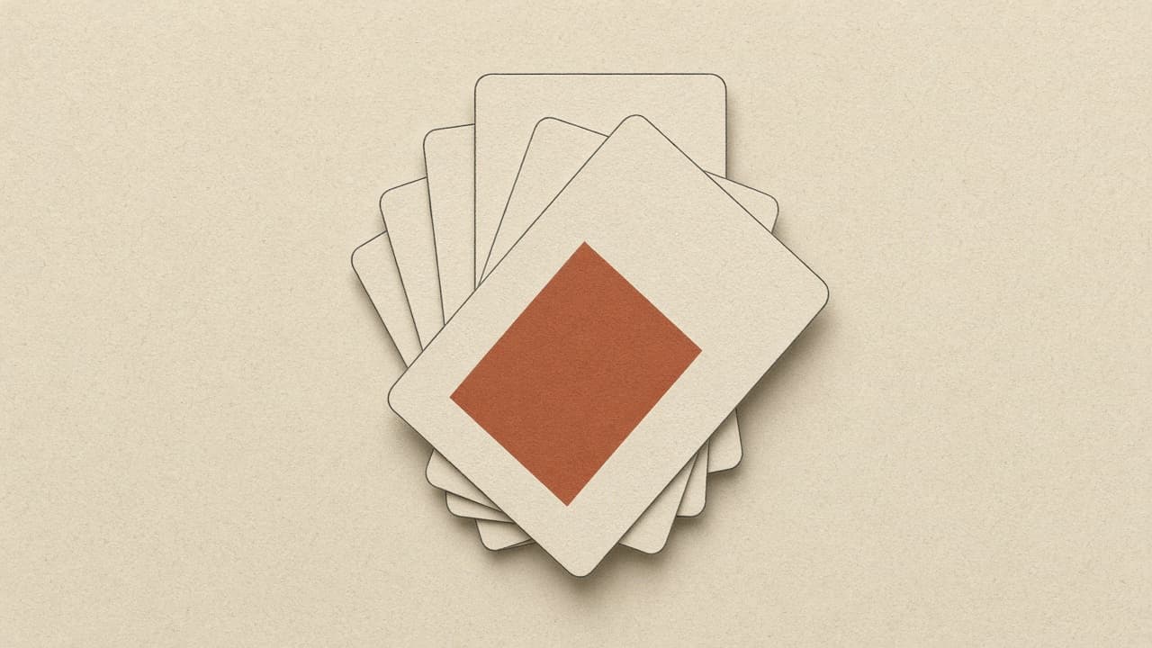 A loose stack of charcoal cards, one marked with a terracotta block